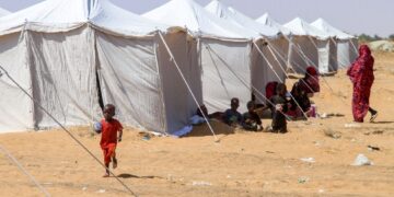 KANAK-kanak Sudan yang berjaya melarikan diri dari al-Fashir duduk di luar khemah di kawasan perlindungan bandar utara Al-Dabba.- AFP