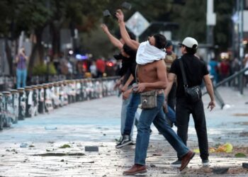 PENUNJUK perasaan membaling batu ke arah Istana Kerajaan Negeri Jalisco semasa perhimpunan menentang kerajaan Presiden Claudia Sheinbaum di Guadalajara, kelmarin.- AFP
