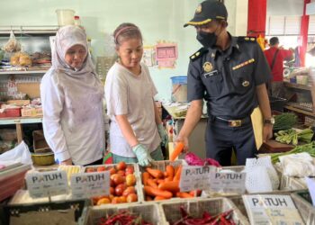 ROHAIDA Hassan (kiri) meninjau salah seorang peniaga sewaktu sesi Walkabout Program Pasar Patuh (3P) di Pasar Awam Kuala Perlis, Kangar, Perlis, semalam. -UTUSAN/ASYRAF MUHAMMAD