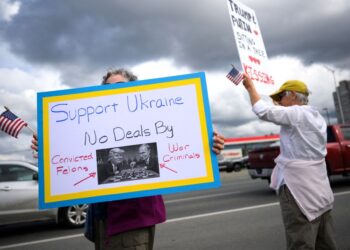 PENUNJUK perasaan mengibarkan bendera dan memegang sepanduk semasa perhimpunan menyokong Ukraine di Anchorage, Alaska, pada 14 Ogos lalu.- AFP