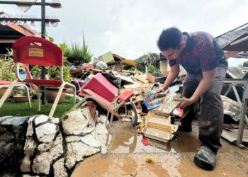PENOLONG Kanan Pendidikan Khas STB, Mohd. Zulkifli Tahir,44, menunjukkan barangan yang musnah termasuk buku-buku ekoran banjir besar di Sekolah Tengku Budriah (STB), Arau, Perlis semalam.-UTUSAN/MOHD. HAFIZ ABD. MUTALIB