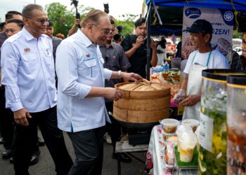 ANWAR Ibrahim menyantuni para peniaga pada Jelajah Malaysia Digital (JMD) Sabah 2025 di Pasar Taman Semarak, Tawau, Sabah semalam. – PEJABAT PERDANA MENTERI