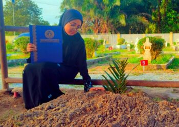 SITI Ruqyah Adnan semasa menziarahi pusara arwah bapanya di Tanah Perkuburan Islam Kampung Sri Aman, Pasir Puteh, Kelantan. 
– UTUSAN/YATIMIN ABDULLAH