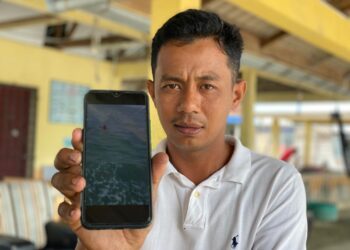MUHD Azhan Azmi menunjukkan gambar wanita terapung yang diselamatkannya di Tanjung Belua ketika ditemui di Pengkalan Nelayan Kampung Sungai Menghulu, Langkawi.