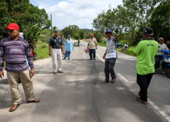 penduduk menunjukkan keadaan jalan rosak yang akibat kerja-kerja penanaman paip  di Jalan Darat, Changlun. – UTUSAN/ SHAHIR NOORDIN