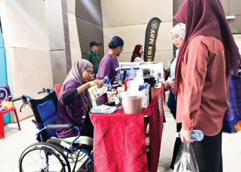 LUMPUH sebelah badan bukan halangan Nurul Hidayah Faizah Abdullah bergelar usahawan dan berniaga pada Karnival Masyarakat Mesra OKU di Dewan Majlis Daerah Jerantut di Jerantut, Pahang. - UTUSAN/SALEHUDIN MAT RASAD