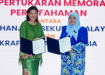 AZALINA Adham (kiri) dan `Ainu Sham Ramli bergambar selepas bertukar memorandum persefahaman (MoU) pada Majlis Pelancaran Festival Batik Lestari 2025 & Panduan Penzahiran Kemampanan Batik (SBDG) di Suruhanjaya Sekuriti Malaysia Bukit Kiara, semalam. – UTUSAN/ISKANDAR ISHAK