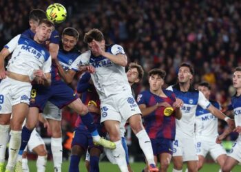 Penyerang Barcelona, Robert Lewandowski dan pemain tengah Deportivo Alaves, Pablo Ibanez (kiri) bersaing mendapatkan bola dalam saingan La Liga di Camp Nou, semalam. - AFP