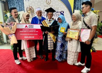 MUHAIMIN Abdul Hamit menunjukkan anugerah yang diterima kepada ahli keluarganya bersempena Konvokesyen UniSIRAJ Ke-8 di Dewan 2020, Kangar, Perlis, semalam. – MINGGUAN/ASYRAF MUHAMMAD