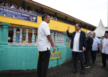 Mohamed Khaled Nordin melambai tangan kepada warga Sekolah Kebangsaan Gembut, Kota Tinggi, Johor ketika melancarkan inisiatif Sekolah Angkat MADANI hari ini.