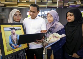 WAN Nasrul Hakim Wan Muhammad (dua dari kiri) bersama isteri, Fatin Sharina A. Halim (dua dari kanan) dan dua anaknya, Wan Aishah Wahidah dan Wan Anisah Farhah (kanan) melihat skrol milik Wan Adlin Nadhilah pada Majlis Konvokesyen UKM ke-53 di Bangi, Selangor, semalam. – UTUSAN/MUHAMAD IQBAL ROSLI