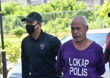 TERTUDUH (tengah) semasa dibawa oleh polis untuk prosiding perbicaraan di Mahkamah Seksyen Kota Bharu, Kelantan hari ini-UTUSAN/KAMARUL BISMI KAMARUZAMAN.