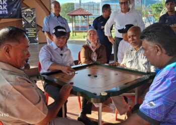 WAN ROSDY Wan Ismail menunjukkan kemahiran bermain karom bersama penduduk di Laman Qulbu di Maran, Pahang. - UTUSAN/SALEHUDIN MAT RASAD