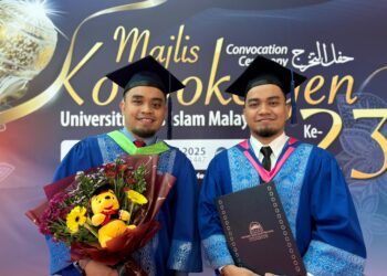 MUHAMMAD Izaan Sabaruddin (kiri) bersama abang kembarnya, Muhammad Izzat bergambar selepas Majlis Konvokesyen USIM Ke-23 di Nilai, Seremban, semalam.