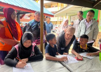 FADHLINA Sidek (tiga dari kanan) beramah mesra dengan salah seorang murid yang ditempatkan di PPS SK Changkat Jawi, Arau, Perlis hari ini. -UTUSAN/ASYRAF MUHAMMAD