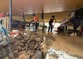 GURU-guru, ibu bapa dan sukarelawan membersihkan lumpur tebal ekoran banjir besar di Sekolah Tengku Budriah (STB), Arau, Perlis semalam. – UTUSAN/MOHD. HAFIZ ABD. MUTALIB