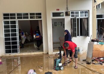 PENDUDUK mula membersihkan rumah selepas banjir mula surut di Taman Bukit Kayangan, Kangar, Perlis semalam.-UTUSAN