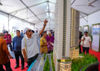 PENDUDUK teruja melihat replika projek pembangunan semula Kampung Sungai Baru selepas majlis pecah tanah di Kampung Sungai Baru, Kuala Lumpur, semalam. - UTUSAN/SADDAM YUSOFF