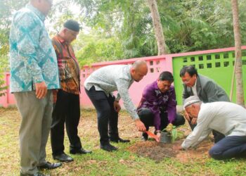 AHMAD Fahmi Ahmad Sarkawi menanam pohon mangga di Santitham Wittaya School selepas merasmikan forum anjuran Persatuan Alumni Universiti-universiti Malaysia di Thailand di Yala, Thailand. – UTUSAN/RAZALI ZAKARIA