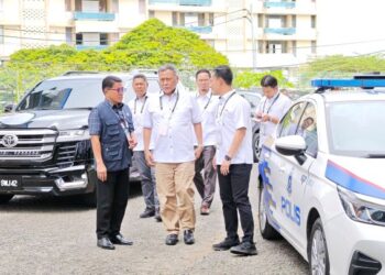 Ramlan (dua dari kanan) bersama beberapa pegawai SPR meninjau proses pembuangan undi awal di Dewan Serbaguna IPD Tawau.