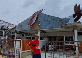 MUHAMMAD Sallehin Mohd. Din menunjukkan keadaan bumbung rumahnya yang musnah dibadai ribut di Taman Nusari Bayu 2, Sendayan, Negeri Sembilan. – UTUSAN/MOHD. SHAHJEHAN MAAMIN