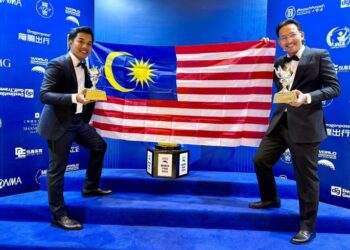 ISYRAF Widad Muhammad Ikmal Opat (kiri) dan Muhammad Adib Ibrahim bergambar bersama trofi selepas muncul naib juara dunia pada Cabaran Golf Korporat Dunia (WCGC) di Kelab Golf Dongzhuang, Shanghai, baru-baru ini.