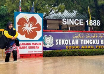 SEORANG guru pulang selepas kawasan Sekolah Tengku Budriah (STB), Arau, Perlis, mula ditenggelami banjir, semalam.  – UTUSAN/MOHD. HAFIZ ABD. MUTALIB
