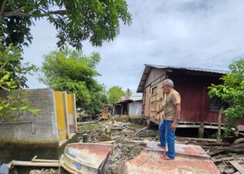 MOHD. Wazir Mokhtar menunjukkan bahagian dapur rumahnya yang musnah dihanyutkan arus sungai di Kampung Lorong Kalat, Batak Rabit, Perak.