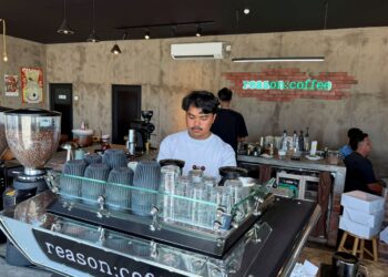 AHMAD Haziq Badrol Hisham menyediakan kopi untuk pelanggan di kafenya di Kuala Terengganu, Terengganu.