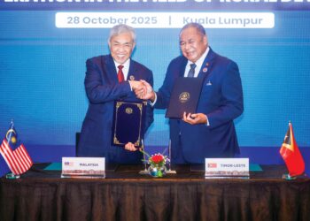 AHMAD Zahid Hamidi (kiri) dan Bendito dos Santos Freitas menunjukkan dokumen yang ditandatangani antara Kerajaan Malaysia dengan Kerajaan
Timor-Leste di Kuala Lumpur, Selasa lalu. – MINGGUAN/ISKANDAR ISHAK