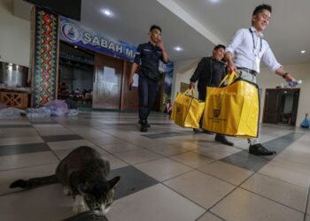 PETUGAS SPR membawa keluar beg peti undi dari Pusat Penjumlahan Undi Pilihan Raya Umum Negeri Sabah ke-17 bagi kawasan N.12 Sulaman, N.13 Pantai Dalit, N.14 Tamparuli dan N.15 Kiulu untuk dibawa ke pusat mengundi ketika tinjauan di Dewan Seri Sulaman, Tuaran.-UTUSAN/AMIR KHALID