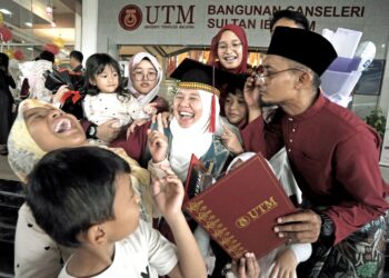 Siti Noraisikin Mohd. Jazuli diraikan oleh suami bersama lapan anak pada Majlis Konvokesyen UTM Ke-69 di Dewan Sultan Iskandar, Skudai, Johor. – UTUSAN/RAJA JAAFAR ALI