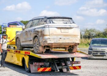 KERETA yang tenggelam banjir di Hat Yai, Thailand ditunda ke tempat pengumpulan kenderaan di Bukit Kayu Hitam, Kubang Pasu. – UTUSAN/ SHAHIR NOORDIN