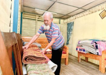RAMLI Mohd. Akib memindahkan barangan ke bahagian atas rumah sebagai persiapan menghadapi banjir di Kampung Air Taling Dangi, Johol, Kuala Pilah. - MINGGUAN/NOR SHAFIQAH MOHD. GHAZALI