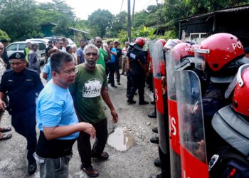 ANGGOTA polis membantu mengawal keselamatan dan ketenteraman bagi kerja-kerja perobohan rumah penduduk di Kampung Papan, Klang, Selangor semalam. – UTUSAN/AFIQ RAZALI