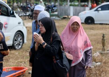 WAN Fatihah Mat Hussin (kiri) turut hadir memberikan penghormatan terakhirnya kepada arwah suami sebelum disemadikan di Tanah Perkuburan Islam Kampung Apam, Pasir Mas, Kelantan hari ini-UTUSAN/KAMARUL BISMI KAMARUZAMAN.