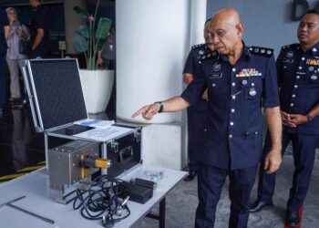 AHMAD Sukarno Mohd. Zahari menunjukkan mesin penanda yang dirampas ketika sidang akhbar di IPD Sentul, Kuala Lumpur. - UTUSAN/ISKANDAR ISHAK