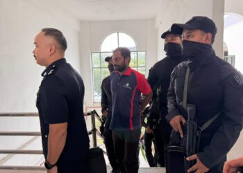 Dinesh Kumar Mandal (tengah) dikawal oleh beberapa anggota polis ketika tiba di Mahkamah Majistret Bukit Mertajam, Pulau Pinang, hari ini.-GAMBAR/SITI NUR MAS ERAH AMRAN