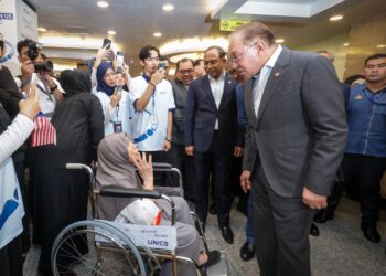 ANWAR Ibrahim beramah mesra dengan seorang pesakit pada Majlis Pelancaran Kolej Universiti IJN di Kuala Lumpur hari ini. - UTUSAN/MUHAMAD IQBAL ROSLI
