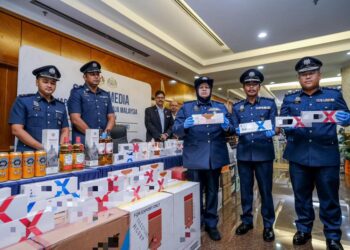 WAN Norizan Wan Daud (tengah) bersama barang rampasan kes melibatkan minuman keras dan rokok putih tak berkastam di Kompleks Kastam WPKL hari ini.