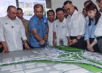 ANWAR Ibrahim (kiri) diberi penerangan mengenai projek penyuraian trafik antara Plaza Tol Juru dan Plaza Tol Sungai Dua atau PTJSD ketika majlis pecah tanah projek itu di tapak ekspo Seberang Jaya, Pulau Pinang, Sabtu lalu.-UTUSAN/DANIAL SAAD