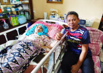 BOLIA Buang (kanan) kini mengambil alih tugas menguruskan anak-anaknya selepas isterinya terlantar sakit.