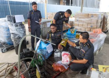 S. JEGAN (duduk, tengah) menunjukkan sebahagian daripada minyak masak peket bersubsidi yang dirampas ketika sidang akhbar di Kompleks Penyimpanan Ekshibit KPDN negeri di Bukit Minyak, Bukit Mertajam, Pulau Pinang.-UTUSAN/DANIAL SAAD