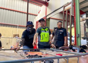 MOHD. Zuhairi Mat Radey menunjukkan minyak pelincir kenderaan tiruan yang belum dibotolkan ketika serbuan di Kampung Baru Ampang, Ampang Jaya, Selangor.