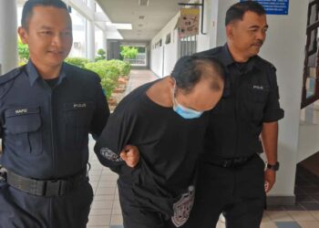 MOHD. Zulkhairi Zakaria diiringi anggota polis dibawa keluar dari Mahkamah Sesyen Melaka, Ayer Keroh selepas mengaku tidak bersalah atas pertuduhan amang seksual fizikal terhadap kanak-kanak perempuan berusia sembilan tahun. - UTUSAN/AMRAN ALI