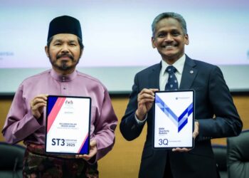 MOHD UZIR MAHIDIN (kiri) dan Gabenor Bank Negara Malaysia (BNM) menunjukkan laporan ekonomi negara suku ketiga di Sasana Kijang, di sini hari ini. - UTUSAN/IQBAL