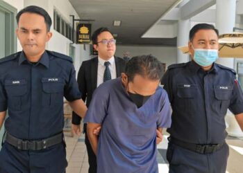 TERTUDUH yang diiringi anggota polis mengaku tidak bersalah di Mahkamah Sesyen Melaka, Ayer Keroh, hari ini atas pertuduhan melakukan amang seksual fizikal terhadap dua remaja perempuan dan melakukan persetubuhan luar tabii terhadap salah seorang mangsa sama di atas katil rumahnya, Oktober lalu. - UTUSAN/AMRAN ALI