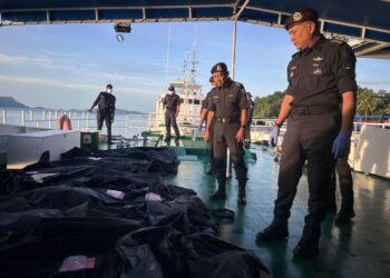KHAIRUL Azhar Nuruddin (kanan) memeriksa 12 mayat PATI yang dihantar ke HSB menggunakan bot polis PLC 5 di Jeti Maritim Malaysia Bukit Malut di Langkawi, Kedah hari ini.