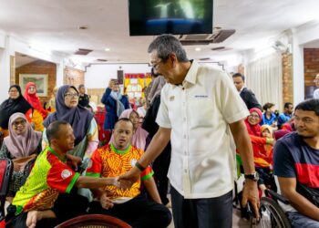 WAN Ahmad Dahlan Abdul Aziz (kanan) semasa menyantuni anak-anak istimewa ketika Program Ziarah Pesara dan Lawatan Kerja di Min House Camp, Kubang Kerian, Kelantan hari ini-UTUSAN/KAMARUL BISMI KAMARUZAMAN.