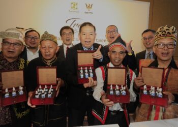 Muhammad Abdullah (tengah), Yeo (belakang, dua kiri), Ken (belakang, dua kanan) bersama-sama tetamu kehormat lain dan wakil komuniti peribumi yang hadir sempena pelancaran Trove Borneo menunjukkan edisi terhad sembilan minyak pati tulen yang diekstrak daripada tumbuhan tempatan Sarawak.